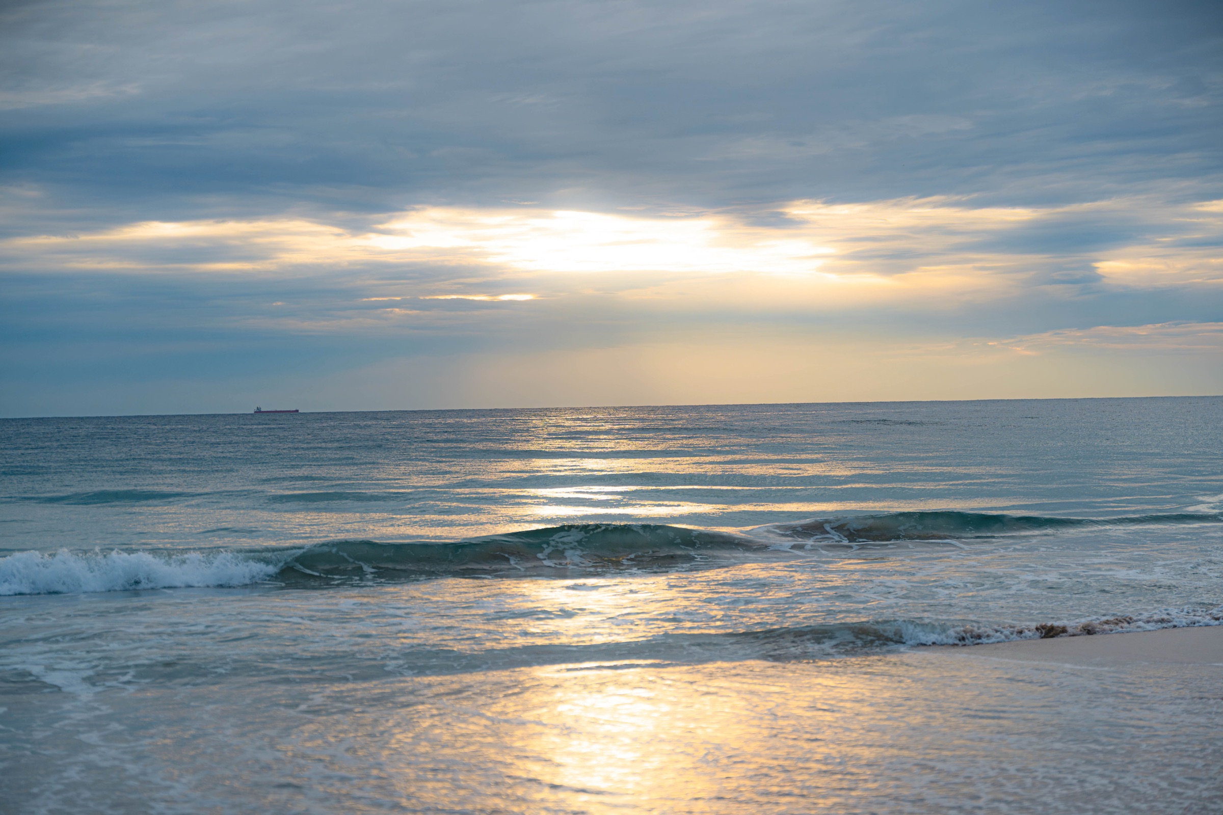 Golden sunset over rolling ocean waves