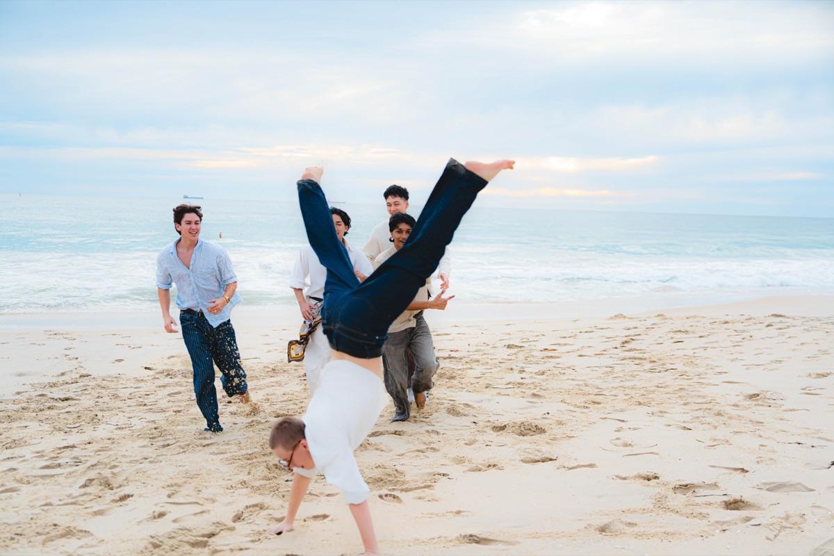 Friends playing on the beach beside the ocean
